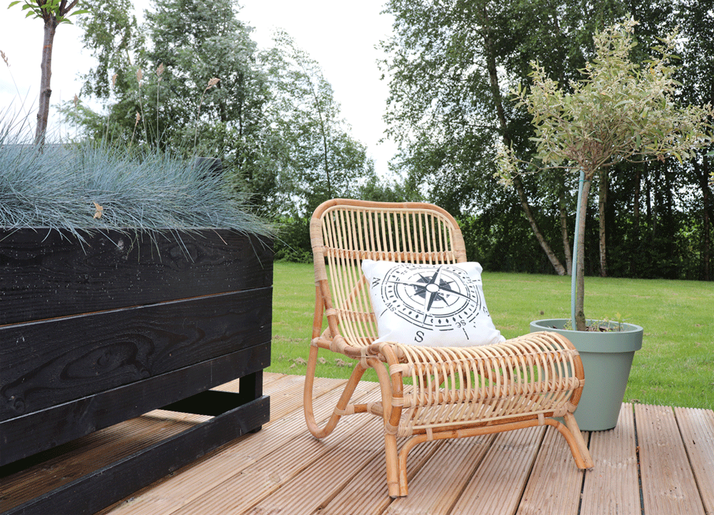 Rotan loungestoel Tim in naturel in een sfeervolle woonkamer
